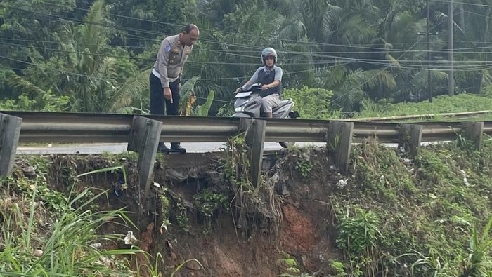 1765364759635-polisi-meninjau-tepian-jalintim-yang-tergerus-longsor-1765351787972_169