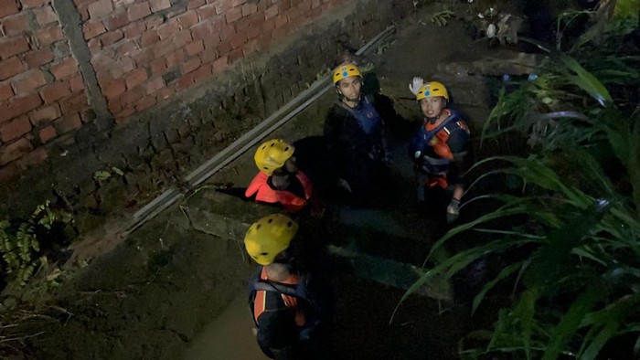 1765602346023-personel-basarnas-saat-menyisir-saluran-air-tempat-bocah-diduga-hanyut-di-jambi-1765550243674_169